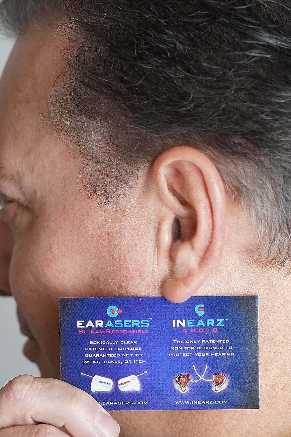 Side profile of ear canal with business card held against face